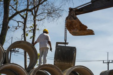 Büyük boruları insana yardım eden bir araca çevirmek için kazıcı kullanmak.