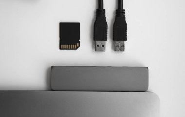 USB Tip-C adaptörlü USB kablosu ve SD kartı olan bir laptop. Laptop için C tipi konektörün altındaki USB adaptörü. Çok farklı portları olan bir bilgisayar için çok portlu istasyon. İnbot Dönüştürücü.