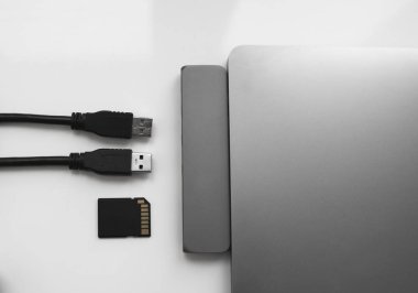USB Tip-C adaptörlü USB kablosu ve SD kartı olan bir laptop. Laptop için C tipi konektörün altındaki USB adaptörü. Çok farklı portları olan bir bilgisayar için çok portlu istasyon. İnbot Dönüştürücü.