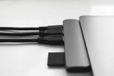 USB Tip-C adaptörlü USB kablosu ve SD kartı olan bir laptop. Laptop için C tipi konektörün altındaki USB adaptörü. Çok farklı portları olan bir bilgisayar için çok portlu istasyon. İnbot Dönüştürücü.