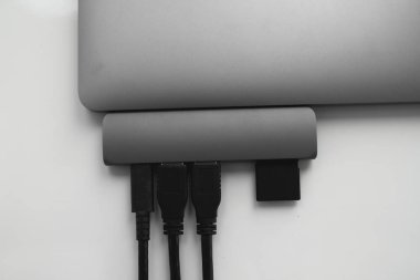 USB Tip-C adaptörlü USB kablosu ve SD kartı olan bir laptop. Laptop için C tipi konektörün altındaki USB adaptörü. Çok farklı portları olan bir bilgisayar için çok portlu istasyon. İnbot Dönüştürücü.