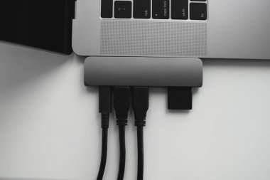 USB Tip-C adaptörlü USB kablosu ve SD kartı olan bir laptop. Laptop için C tipi konektörün altındaki USB adaptörü. Çok farklı portları olan bir bilgisayar için çok portlu istasyon. İnbot Dönüştürücü.