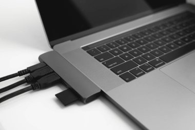 USB Tip-C adaptörlü USB kablosu ve SD kartı olan bir laptop. Laptop için C tipi konektörün altındaki USB adaptörü. Çok farklı portları olan bir bilgisayar için çok portlu istasyon. İnbot Dönüştürücü.