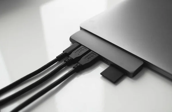 Portátil con adaptador USB Tipo-C con cables USB enchufados y tarjeta SD. El adaptador USB debajo del conector Tipo-C para portátil. Estación multipuerto para portátil con múltiples puertos diferentes. Convertidor Hub. — Foto de Stock