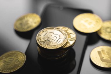Masasında bir sürü bozuk para olan akıllı bir telefon üzerinde altın bitcoin para. Sanal kripto para birimi kavramı. Sanal para madenciliği çevrimiçi işyeri. Bitcoin ticareti.