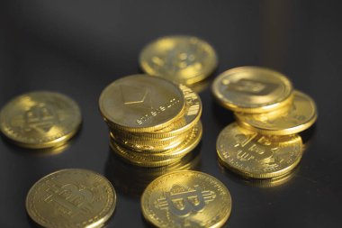 Bir yığın altın Ethereum Bitcoin madeni para ve masada bir sürü bitcoin var. Sanal kripto para birimi kavramı. Sanal para madenciliği çevrimiçi işyeri. Bitcoin ticareti.
