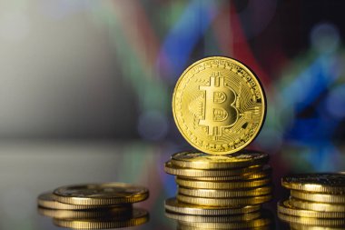 Bitcoinler ve sanal para konsepti. Şifreleme parasının büyüyen ve azalan değerinin grafiği olan madeni paraların üzerindeki altın bitsikkeler. Madencilik ya da engelleme teknolojisi.