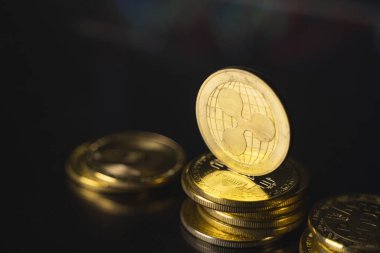 Dalgalı para ve sanal para konsepti. Şifreleme para biriminin büyüyen ve azalan değerinin grafiğiyle bir yığın madeni para üzerinde altın dalgalanması. Madencilik ya da engelleme teknolojisi.