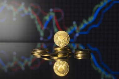 Monero ve sanal para kavramı. Altın monero bitcoins bir yığın madeni para üzerinde büyüyen ve düşen kripto para değerleri. Madencilik ya da engelleme teknolojisi.