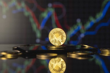 Monero ve sanal para kavramı. Altın monero bitcoins bir yığın madeni para üzerinde büyüyen ve düşen kripto para değerleri. Madencilik ya da engelleme teknolojisi.