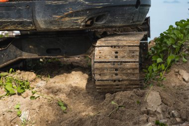 Mavi gökyüzü ve deniz inşaat sitesinde bir iş için bir yerde küçük turuncu Ekskavatör. Zemin üzerine mavi deniz ile bir yerde duran küçük paletli ekskavatör. Ağır sanayi.