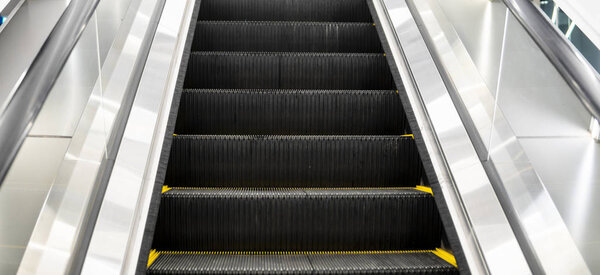 Ditry stairs on Escalator with yellow strips.