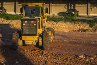 Grader yol inşaatında çalışıyor. Sınıf endüstriyel makine yeni yollar inşa ediyor. Otoyolda çalışan ağır iş makineleri. İnşaat malzemeleri. Yolun sıkıştırması.