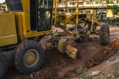 Grader yol inşaatında çalışıyor. Sınıf endüstriyel makine yeni yollar inşa ediyor. Otoyolda çalışan ağır iş makineleri. İnşaat malzemeleri. Yolun sıkıştırması.