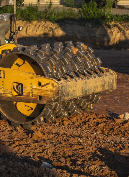 Soil compactor with vibratory padfoot drum. Heavy duty machinery working on highway construction site. Vehicle for soil compaction. Road construction equipment. Paving. Compaction of the road. — Stock Photo, Image