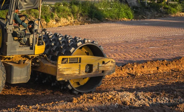 Soil compactor with vibratory padfoot drum. Heavy duty machinery working on highway construction site. Vehicle for soil compaction. Road construction equipment. Paving. Compaction of the road. — Stock Photo, Image