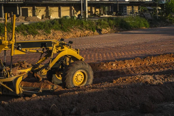 Grader está trabajando en la construcción de carreteras. Grader máquina industrial en la construcción de nuevas carreteras. Maquinaria de servicio pesado trabajando en carretera. Equipo de construcción. Compactación de la carretera . —  Fotos de Stock