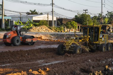 VİETNAM, HO CHI MINH - 15 Mayıs 2019: Grader yol inşaatında çalışıyor. Sınıf endüstriyel makine yeni yollar inşa ediyor. Otoyolda çalışan ağır iş makineleri.