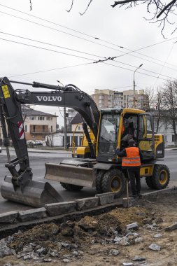 Sarı kazıcı caddedeki bir yolun şantiyesinde duruyor. Ağır endüstri. Bir yol inşaatı.