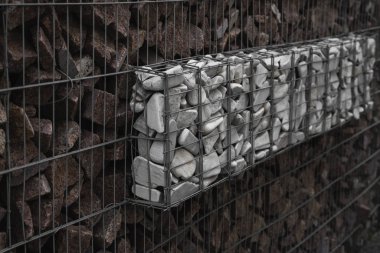 Metal ve taşı ahenk içinde kullanan taş bir duvar. İnşaat için doğal kaynakları kullanan ekoloji dostu. Çöken taşı engellemek için taş duvarlar. Ağla kaplı taş duvar..