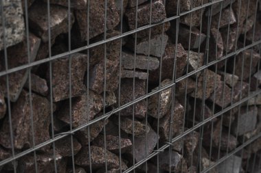 Metal ve taşı ahenk içinde kullanan taş bir duvar. İnşaat için doğal kaynakları kullanan ekoloji dostu. Çöken taşı engellemek için taş duvarlar. Ağla kaplı taş duvar..