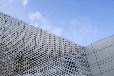 Arka planında mavi gökyüzü olan modern bir binanın mimarisi. Ön tasarım.