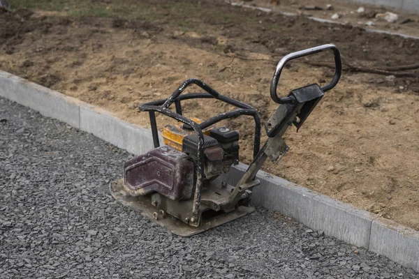 Vibrational paving stone machine for finish on a sidewalk road construction site. — Stock Photo, Image