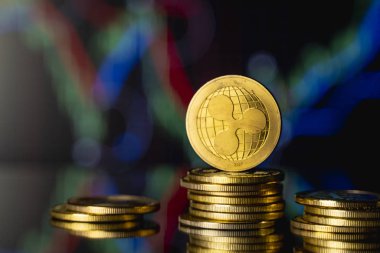 Dalgalı para ve sanal para konsepti. Şifreleme para biriminin büyüyen ve azalan değerinin grafiğiyle bir yığın madeni para üzerinde altın dalgalanması. Madencilik ya da engelleme teknolojisi.