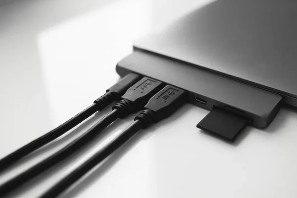 Laptop z adapterem USB Type-C z podłączonymi kablami USB i kartą SD. Adapter USB pod złączem Type-C do laptopa. Stacja Multiport dla laptopa z wieloma różnymi portami. Konwerter piast. — Zdjęcie stockowe