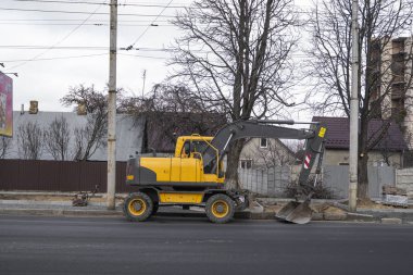 Sarı kazıcı caddedeki bir yolun şantiyesinde duruyor. Ağır endüstri. Bir yol inşaatı.