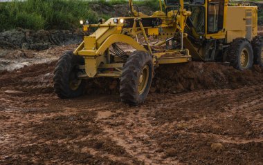 Grader yol inşaatında çalışıyor. Sınıf endüstriyel makine yeni yollar inşa ediyor. Otoyolda çalışan ağır iş makineleri. İnşaat malzemeleri. Yolun sıkıştırması.