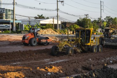 VİETNAM, HO CHI MINH - 15 Mayıs 2019: Grader yol inşaatında çalışıyor. Sınıf endüstriyel makine yeni yollar inşa ediyor. Otoyolda çalışan ağır iş makineleri.