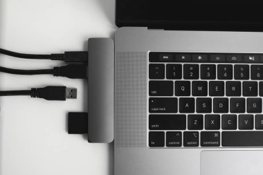 USB Tip-C adaptörlü USB kablosu ve SD kartı olan bir laptop. Laptop için C tipi konektörün altındaki USB adaptörü. Çok farklı portları olan bir bilgisayar için çok portlu istasyon. İnbot Dönüştürücü.