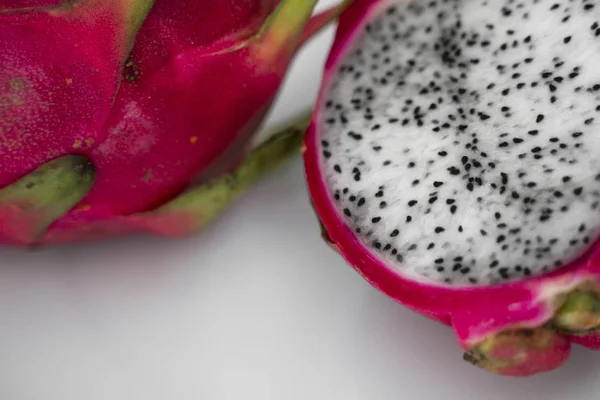 Drakfrukt. Vibrerande drake frukt på vit bakgrund. Skivad vit drake frukt eller pitaya på vit tallrik på bordet, närbild. Tropiska och exotiska frukter. Friska och vitamin livsmedel koncept. — Stockfoto