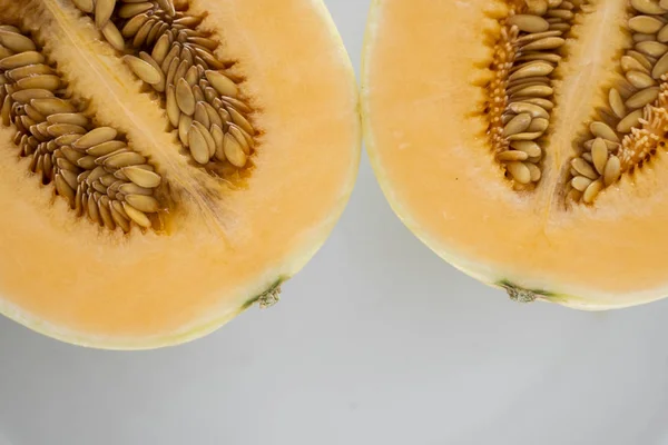 Fresh sweet orange melon on the white plate as a background with a selective focusing. Useful and vitamin-rich food. Vegeterian. — ストック写真