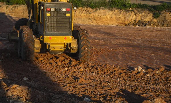 Grader está trabajando en la construcción de carreteras. Grader máquina industrial en la construcción de nuevas carreteras. Maquinaria de servicio pesado trabajando en carretera. Equipo de construcción. Compactación de la carretera . —  Fotos de Stock