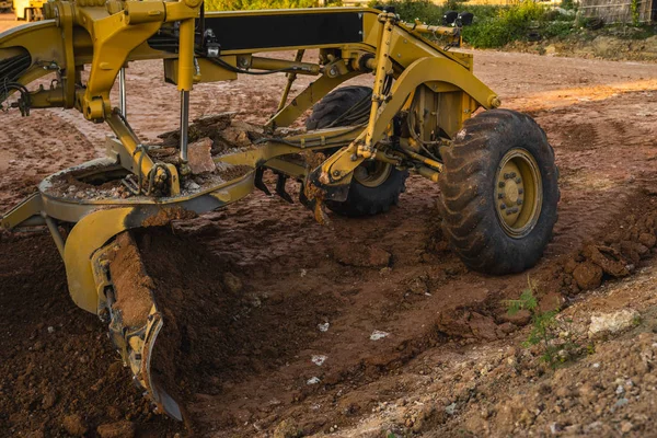 Grader is working on road construction. Grader industrial machine on construction of new roads. Heavy duty machinery working on highway. Construction equipment. Compaction of the road. — Stock Photo, Image