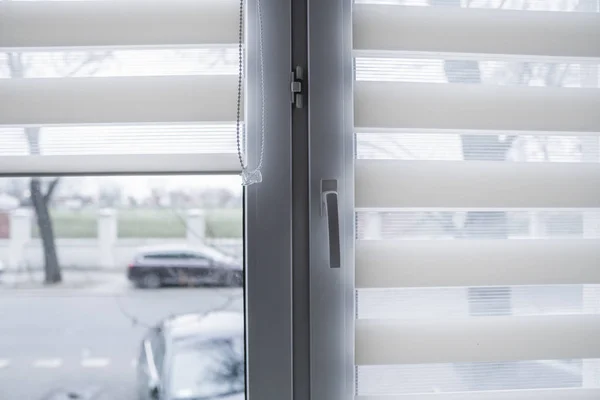 Witte stof rolgordijnen op het witte plastic raam in de woonkamer. Rolgordijnen binnen. — Stockfoto