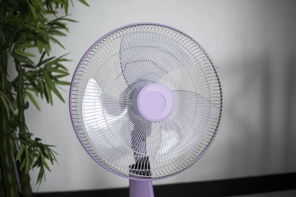 Moderno ventilador eléctrico violeta en una sala de estar salvando a la gente de la temperatura caliente en los días de verano . — Foto de Stock