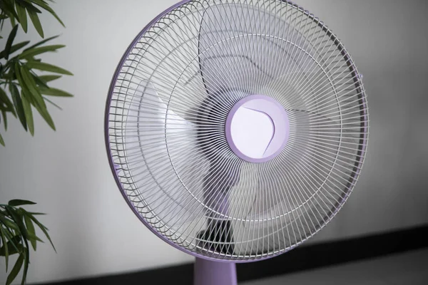 Moderno ventilador eléctrico violeta en una sala de estar salvando a la gente de la temperatura caliente en los días de verano . — Foto de Stock