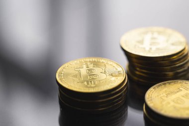 Masanın yansıyan bir yüzeyinde altın bitcoin paraları yığını. Sanal kripto para birimi kavramı. Sanal para madenciliği. Bitcoin ticareti.