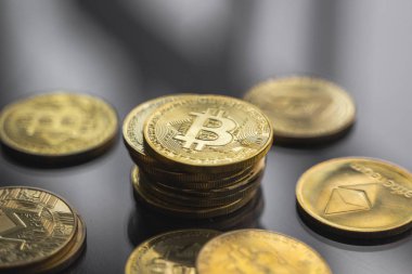 Masanın yansıyan bir yüzeyinde altın bitcoin paraları yığını. Sanal kripto para birimi kavramı. Sanal para madenciliği. Bitcoin ticareti.