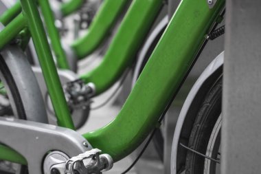 Sokak taşımacılığı yeşil hibrit bisikletler ve şehirde dolaşmak için elektronik ödeme formu kiralık ağ otoparkında sıra bekleyip bisikletçilerin bisiklet yolculuğu yapmasını bekliyor..