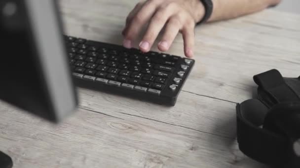 Estudante de empresário ou colaborador independente em uma camisa que se senta contra o monitor do computador e digita um teclado em uma mesa no escritório. Trabalhando em seu laptop no escritório . — Vídeo de Stock