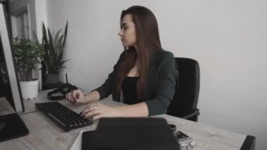 Genç esmer kadın servis operatörü ofisi arıyor. Genç müşteri destek müdürü sorulara kulaklıkla cevap vererek tüketiciye danışıyor. Gülümseyen iş kadını müşteri destek ajanı.