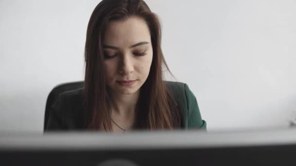 Bruneta pracuje před monitorem v kanceláři. Podnikatelka pracující v počítači na kooperačním prostoru. Portrét šťastné dámy, jak píše na pracovišti. Profesionální pracovnice pracující s PC. — Stock video