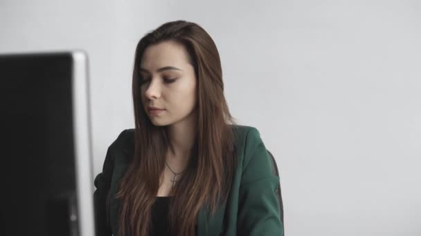 Une femme brune travaille devant un moniteur dans un bureau. Femme d'affaires travaillant à l'ordinateur dans un espace de coworking. Portrait de dame heureuse tapant sur le lieu de travail. Femme professionnelle travaillant avec PC . — Video