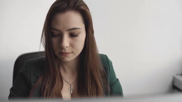 Brünette Frau arbeitet vor einem Monitor in einem Büro. Geschäftsfrau arbeitet am Computer im Coworking Space. Porträt einer glücklichen Frau, die am Arbeitsplatz tippt. weibliche professionelle Arbeit mit dem PC. — Stockvideo