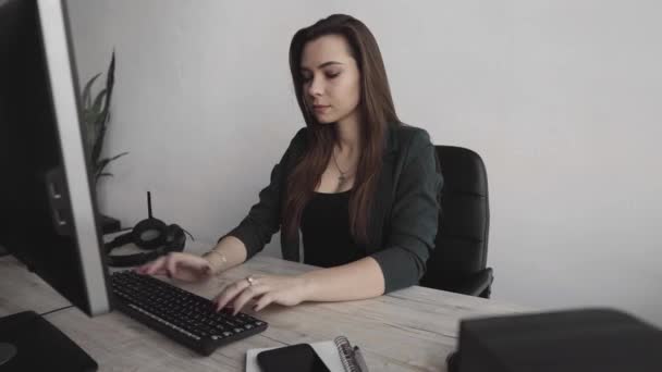 Esmer kadın bir ofiste monitörün önünde çalışıyor. İş kadını ortak çalışma alanında bilgisayar başında çalışıyor. İş yerinde yazan mutlu bir bayanın portresi. PC ile çalışan kadın profesyonel. — Stok video
