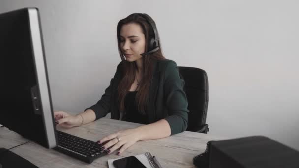 De jonge Brunette-dienstbode belt. Jonge customer support manager consultancy consument door headset beantwoorden van vragen. Lachende zakelijke vrouw customer support agent. — Stockvideo